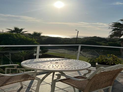 a table and two chairs on a balcony with the ocean at Benri B&B & Self-Catering in Gonubie