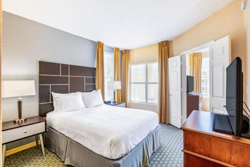 a hotel room with a bed and a flat screen tv at Vacation Village at Parkway in Orlando