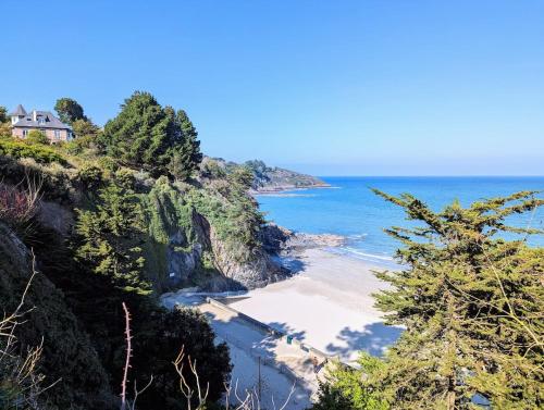 - une vue sur la plage avec une maison sur une falaise dans l'établissement La corniche- vue panoramique sur mer, à Binic