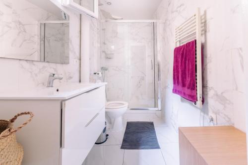 une salle de bain blanche avec un lavabo et des toilettes dans l'établissement Le Pinky Bird - Lafayette Paris, à Paris