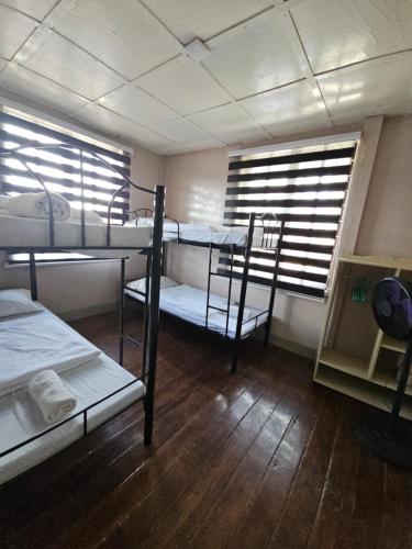 Habitación con 3 literas y 2 ventanas. en Furnished 3 Bedroom House near Camp John Hay, en Baguio