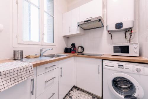 une cuisine blanche avec un évier et une machine à laver dans l'établissement Le Pinky Bird - Lafayette Paris, à Paris