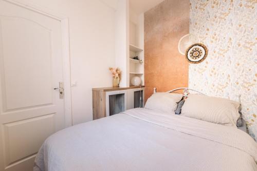 une chambre avec un lit blanc et un mur dans l'établissement Le Pinky Bird - Lafayette Paris, à Paris