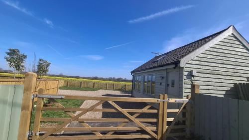 a barn with a wooden gate and a fence at The Nook in Debenham