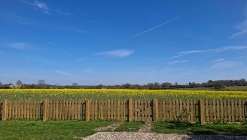 a wooden fence in front of a field of flowers at The Nook in Debenham