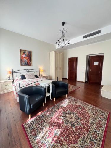 a bedroom with a bed and a couch and a rug at Park Villa - Boutique Hotel in Timişoara