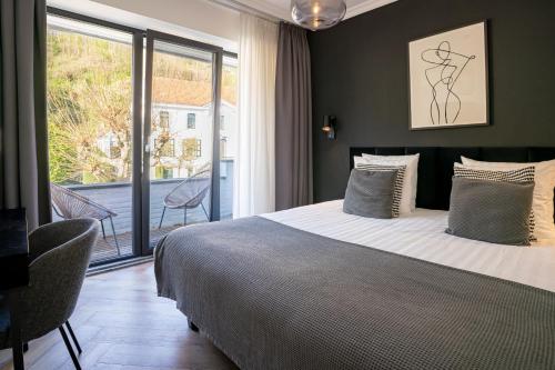 a bedroom with a large bed and a balcony at Hotel Janssen in Valkenburg