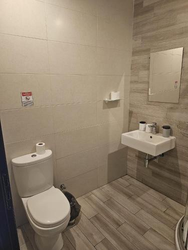 a bathroom with a toilet and a sink at Napoli Suites Studios Aparthotel in St Julian's