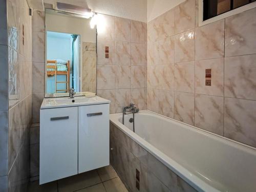 La salle de bains est pourvue d'une baignoire, d'un lavabo et d'une baignoire. dans l'établissement Studio Calme au Lavandou, 500m Plage, Piscine, Parking, Clim, Terrasse Privative, 4 Couchages - FR-1-803-7, au Lavandou
