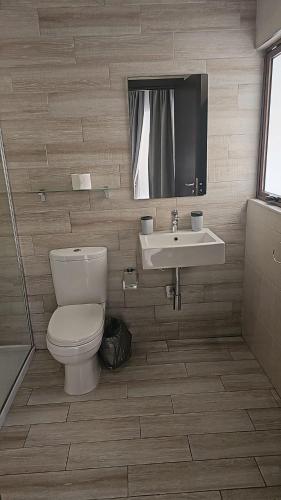 a bathroom with a toilet and a sink at Napoli Suites Studios Aparthotel in St Julian's