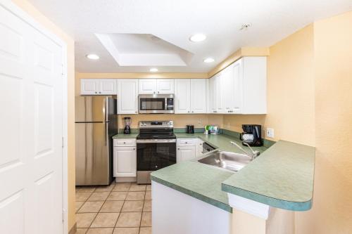 a kitchen with white cabinets and a sink at Vacation Village at Parkway in Orlando