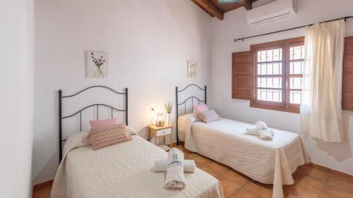 a bedroom with two beds and a window at Casa Berrocal Álora by Ruralidays in Alora