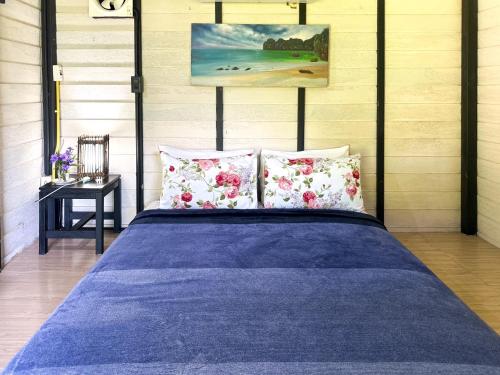 a bedroom with a blue bed with two pillows at Baan Suanthip Homestay - Aoluek Natural Retreat in Ao Luk