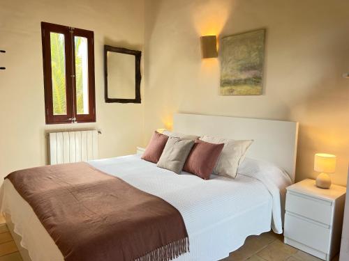 a bedroom with a large white bed with pillows at Casa Arco in Costitx