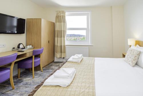 a hotel room with a bed and a desk at Majestic Hotel Eastbourne by Belvilla in Eastbourne