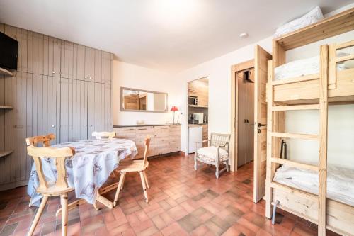 une chambre avec une table, des chaises et des lits superposés dans l'établissement OLYMPIQUE S4 Studio au pied des pistes et de l'ESF, à Morzine