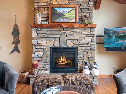 a stone fireplace in a living room with a fire place at Happy Landing Cabin in Cross Lake
