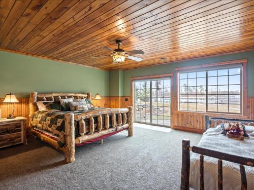 a bedroom with two beds and a wooden ceiling at Happy Landing Cabin in Cross Lake