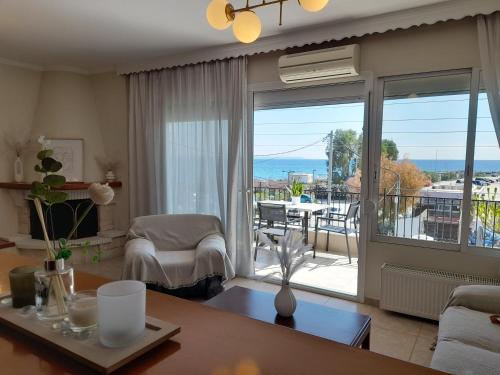 a living room with a view of a balcony at Zozi's home N.MOYDANIA in Nea Moudania