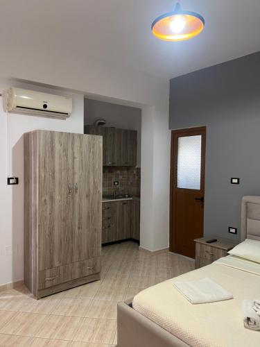a bedroom with a bed and a wooden cabinet at House Pollo in Ksamil