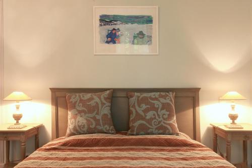 a bedroom with a bed with two lamps and a picture on the wall at Château de la Prade in Bram