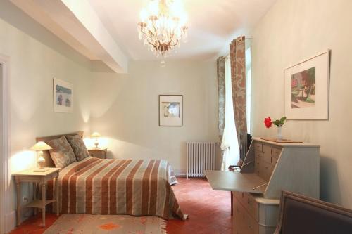 a bedroom with a bed and a desk and a desk at Château de la Prade in Bram