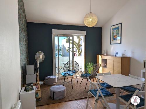 un salon avec une table et des chaises dans l'établissement Picolla Caletta, à Les Sables-dʼOlonne