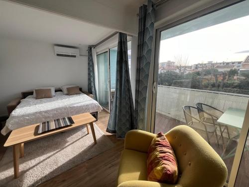 une chambre avec un lit, un canapé et une fenêtre dans l'établissement Le Candie T3 Bord de Mer Piscine et Parking, à Canet