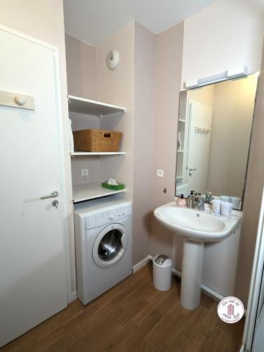 une salle de bain avec une machine à laver et un lavabo dans l'établissement Picolla Caletta, à Les Sables-dʼOlonne
