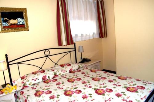 a bedroom with a bed with a floral bedspread at Park Villa - Boutique Hotel in Timişoara