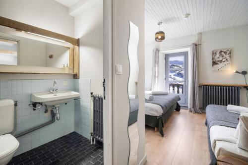 a bathroom with a sink and a toilet and a bedroom at CHALET AUBERGE - Les Mélèzes in Tignes