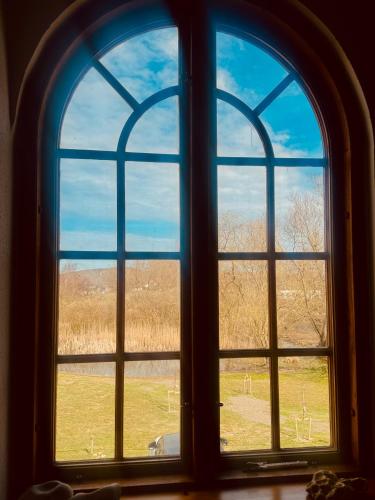 an arched window with a view of a field at Kåseberga Hideout in Kåseberga