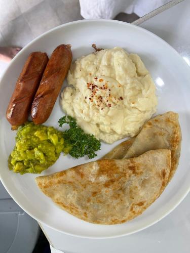 a plate of food with sausage and eggs and toast at Water's Edge Villa in Ahangama