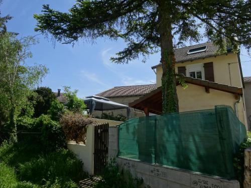 a house with a fence and a tree at Gîte des Pleiades in Villemoirieu