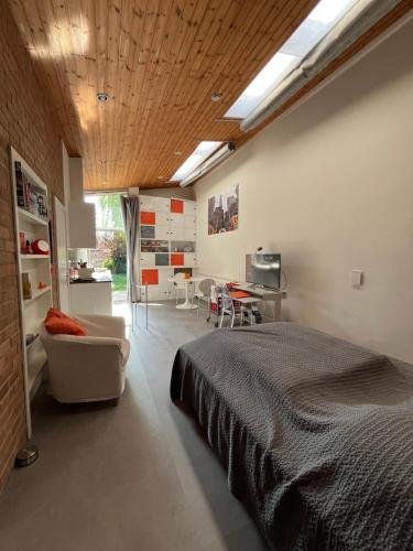 ein Schlafzimmer mit einem Bett, einer Couch und einem Tisch in der Unterkunft Studio vintage banlieue BXL in Genval