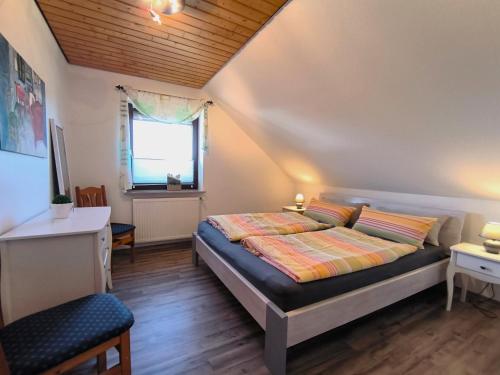 a bedroom with a bed and a desk and a window at Lorenz große FeWo mit sonnigem Balkon in ruhiger Lage in Silberstedt