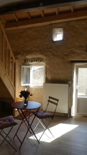 une chambre avec une table, deux chaises et une table dans l'établissement Le Nid, petit gîte de campagne, à Boffres