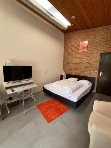 ein Schlafzimmer mit Bett und Flachbildfernseher in der Unterkunft Studio vintage banlieue BXL in Genval