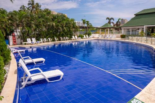 einen Pool mit zwei Liegestühlen in einem Resort in der Unterkunft Sanha Plus Hotel in Santa Marta