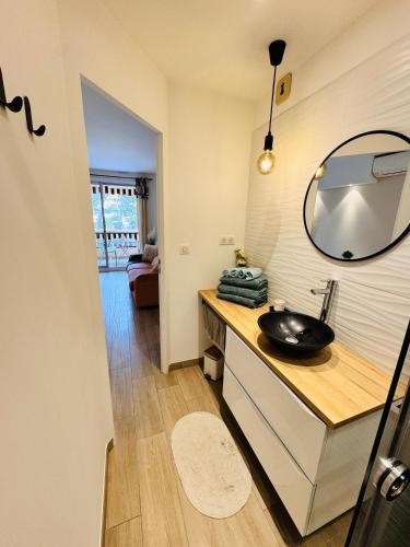 une salle de bain avec un lavabo et un miroir sur un comptoir dans l'établissement Plage à 3 minutes à pied, à Saint-Raphaël
