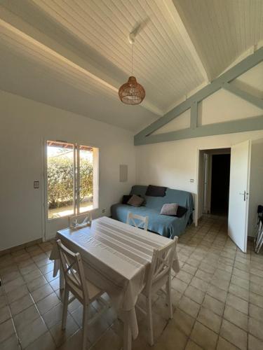 un salon avec une table et un canapé dans l'établissement Les Pignes, à Mimizan