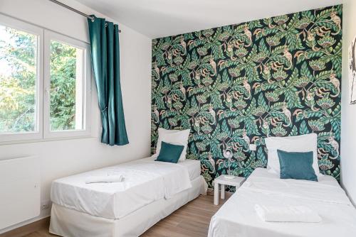 - 2 lits dans une chambre avec papier peint floral dans l'établissement Apartment 2 bedroomed Lena Montry, à Montry