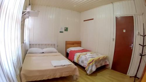a small room with two beds in it at Pousada e Hospedaria Alternativa Ladi Laura in Urubici