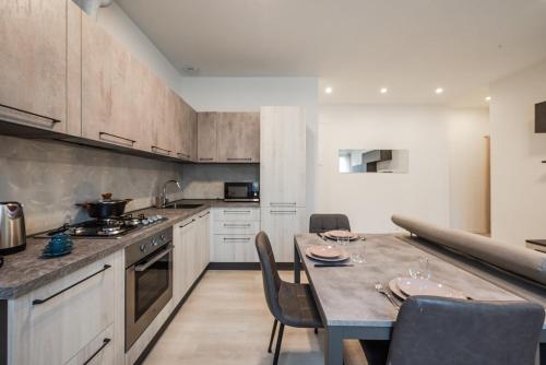 a kitchen with a table and some chairs in it at Rapallo Center Sea Just Steps Away - Aria Condizionata - WiFi in Rapallo