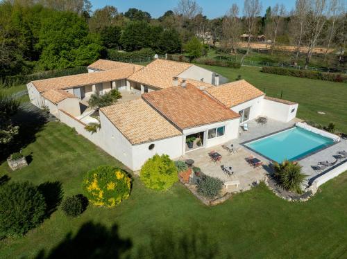 une vue aérienne d'une maison avec piscine dans l'établissement L'Hacienda, aux Mathes