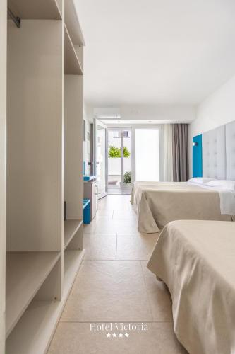 a hotel room with two beds and a hallway at Hotel Victoria in Torre Santa Sabina