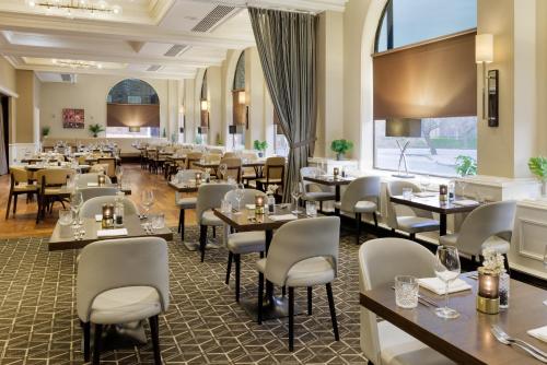 a restaurant with tables and chairs and a large window at Hilton York in York