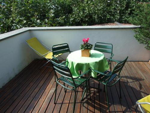 a table and chairs on a deck with a plant on it at Agriturismo Cà Del Lago in Gravedona