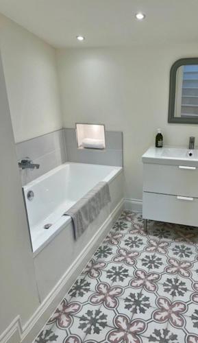 une salle de bain avec une baignoire et un lavabo dans l'établissement The Dovecote, à Loubès-Bernac