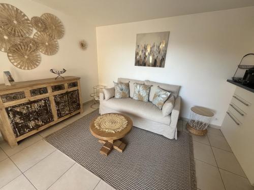 un salon avec un canapé et une table dans l'établissement Frejus Plage Le Capitole T2 35m2 Climatise balcon, à Fréjus